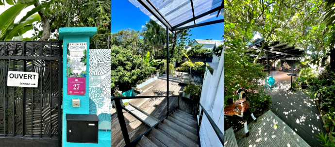 Entrée turquoise avec pancarte Ouvert, escalier en bois et deck ombragé de la Villa Cachée à Nouméa