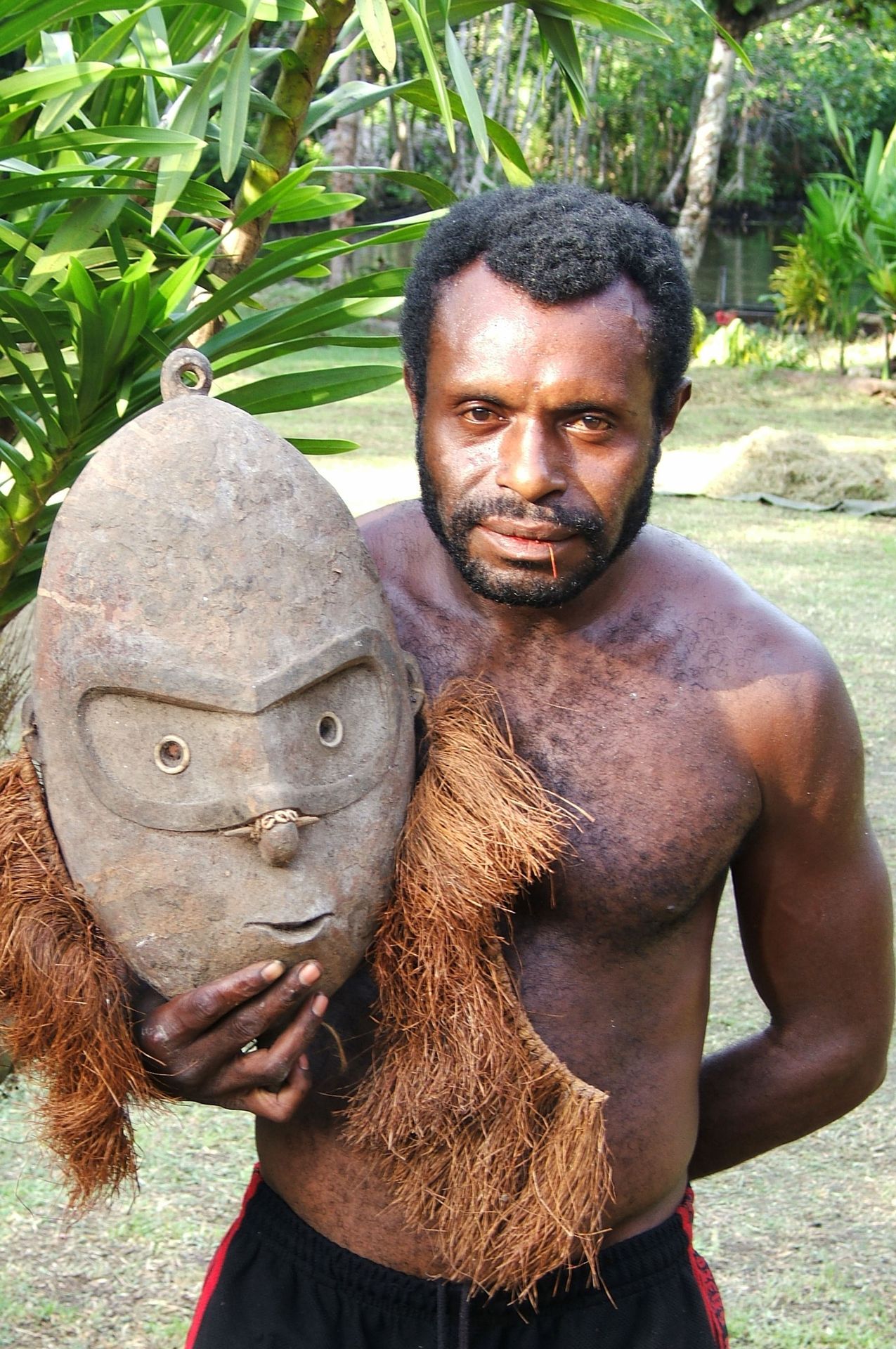 Homme tenant un masque traditionnel de l'île Manam, Papouasie-Nouvelle-Guinée