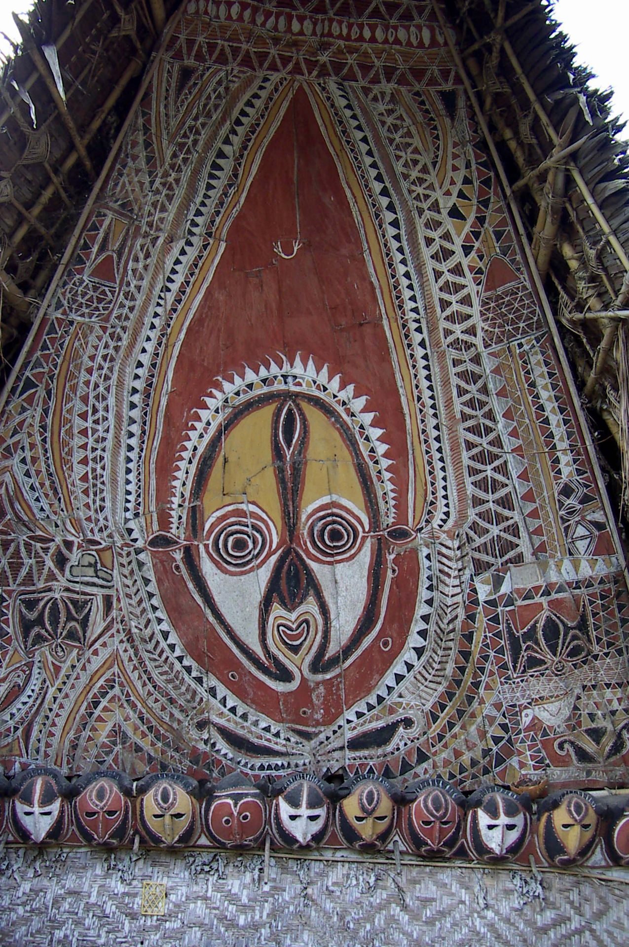 Linteau peint d'une maison cérémonielle abelam, visage ancestral et masques, Papouasie-Nouvelle-Guinée