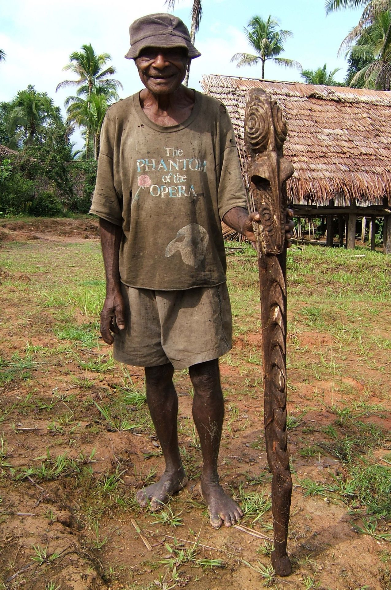 Homme âgé auprès d'une figure yipwon sculptée, région du fleuve Korewori, Papouasie-Nouvelle-Guinée