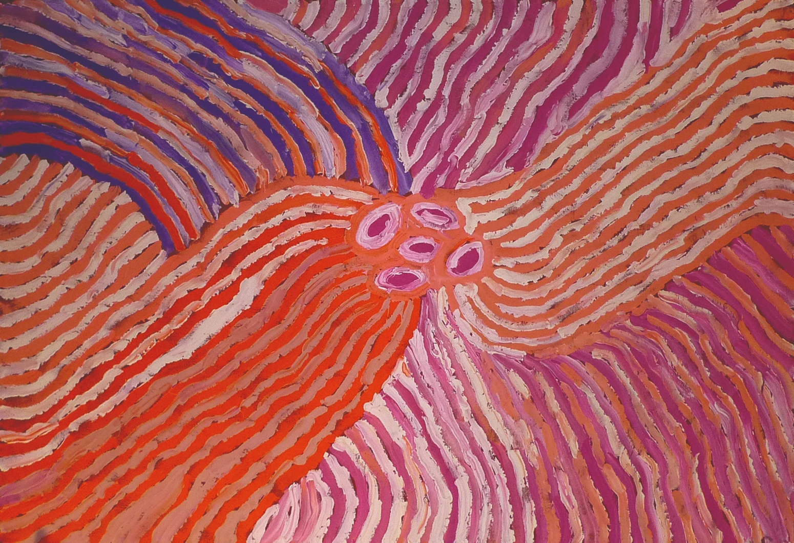 Toile d'art aborigène par l'artiste Makinti Napanangka, motifs radiants orange, rose et violet partant de formes ovales centrales
