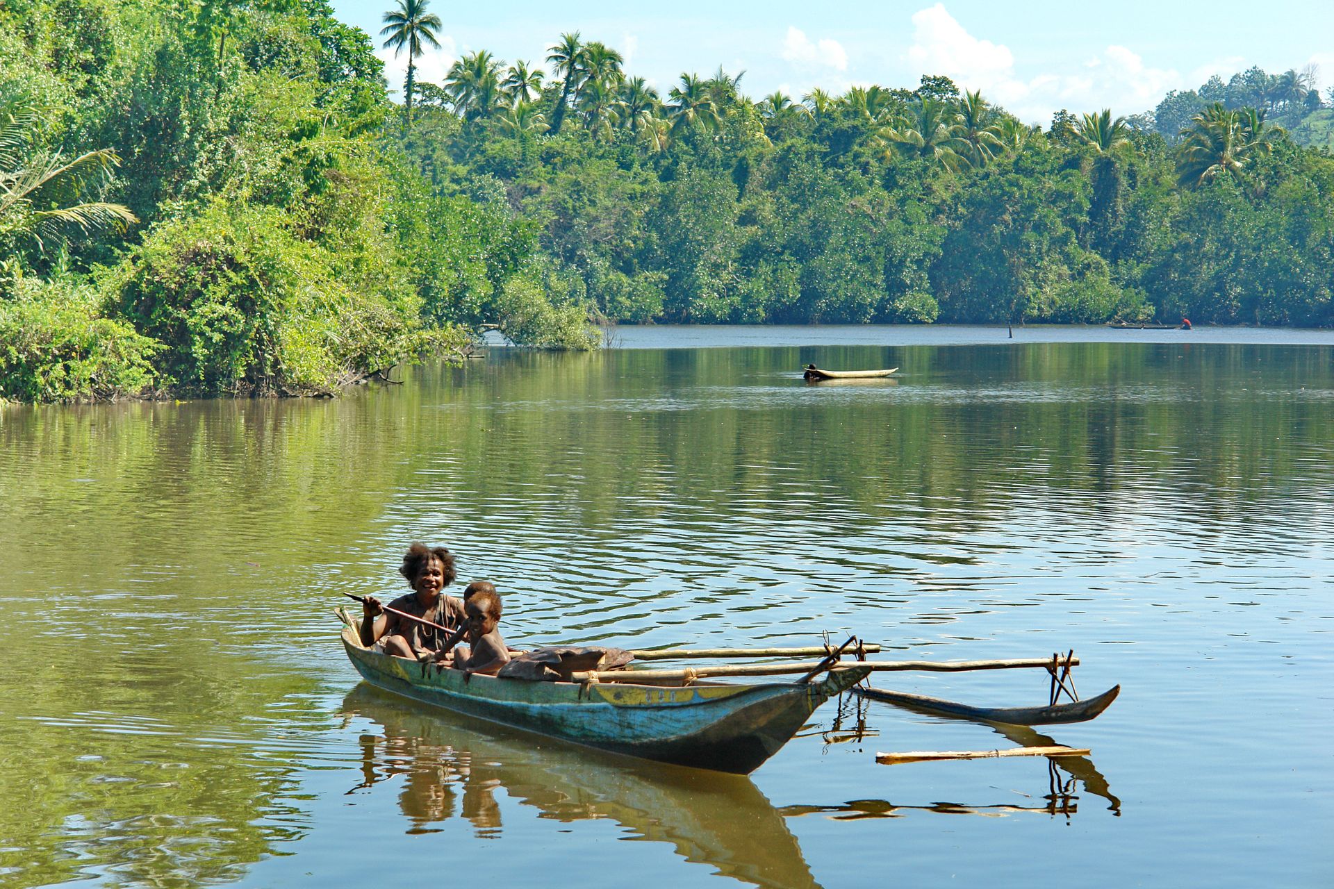 Famille papoue en pirogue traditionnelle sur un fleuve, Papouasie-Nouvelle-Guinée