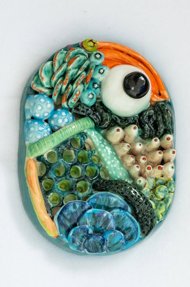 Céramique en relief de Sophie Borneck aux motifs cellulaires bleus et orange, exposition ENTROPIE