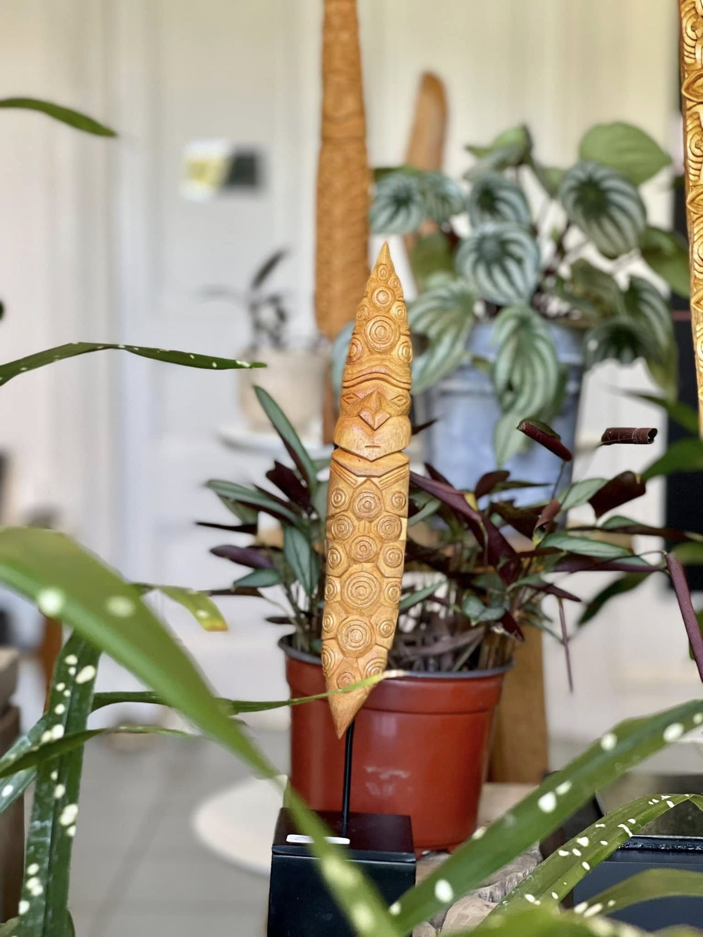 Totem kanak sculpté par Hervé Brukoa dans un pot, visage aux motifs circulaires gravés dans le bois